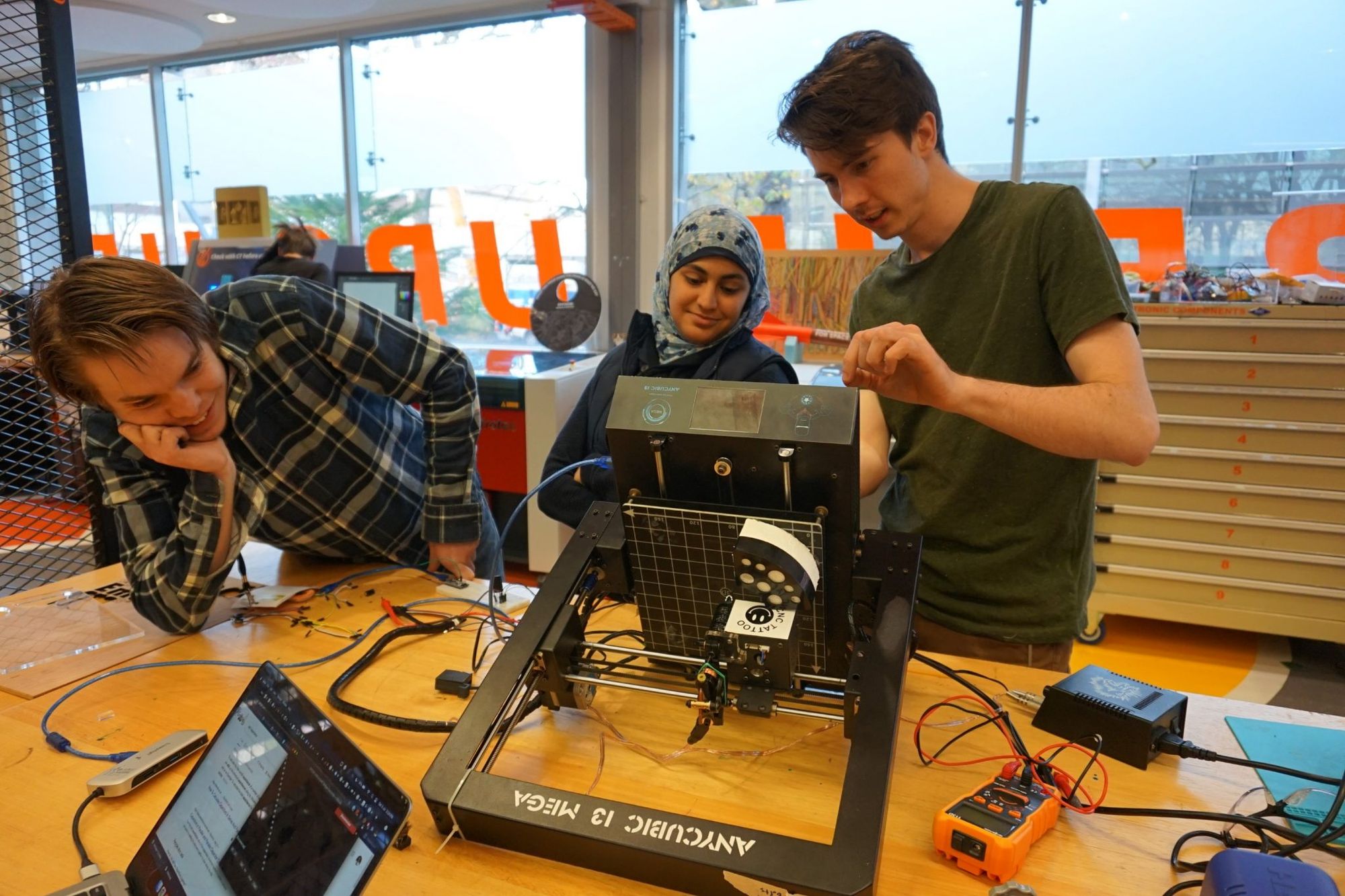 Maker Club members tinkering with a 3D Printer